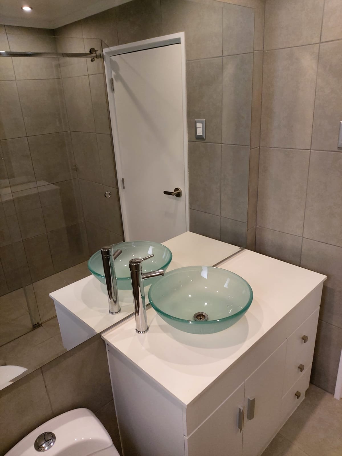 Baño remodelado con doble lavamanos de vidrio, La Reina