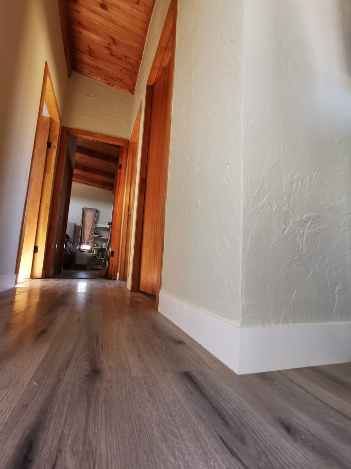 Pasillo con piso flotante nuevo en vivienda de techumbre de madera, La Reina