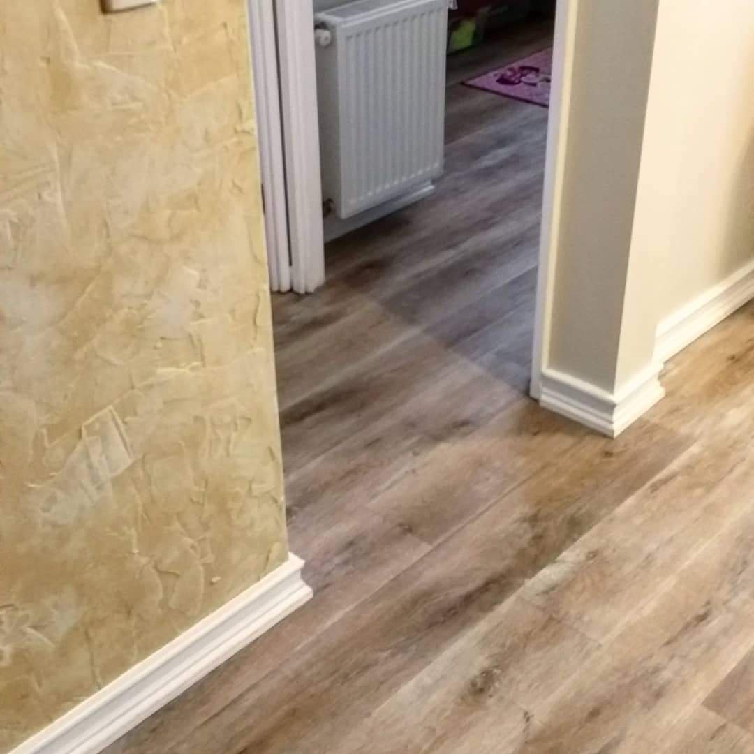 Pasillo con piso flotante nuevo y muro con efecto decorativo dorado, Ñuñoa