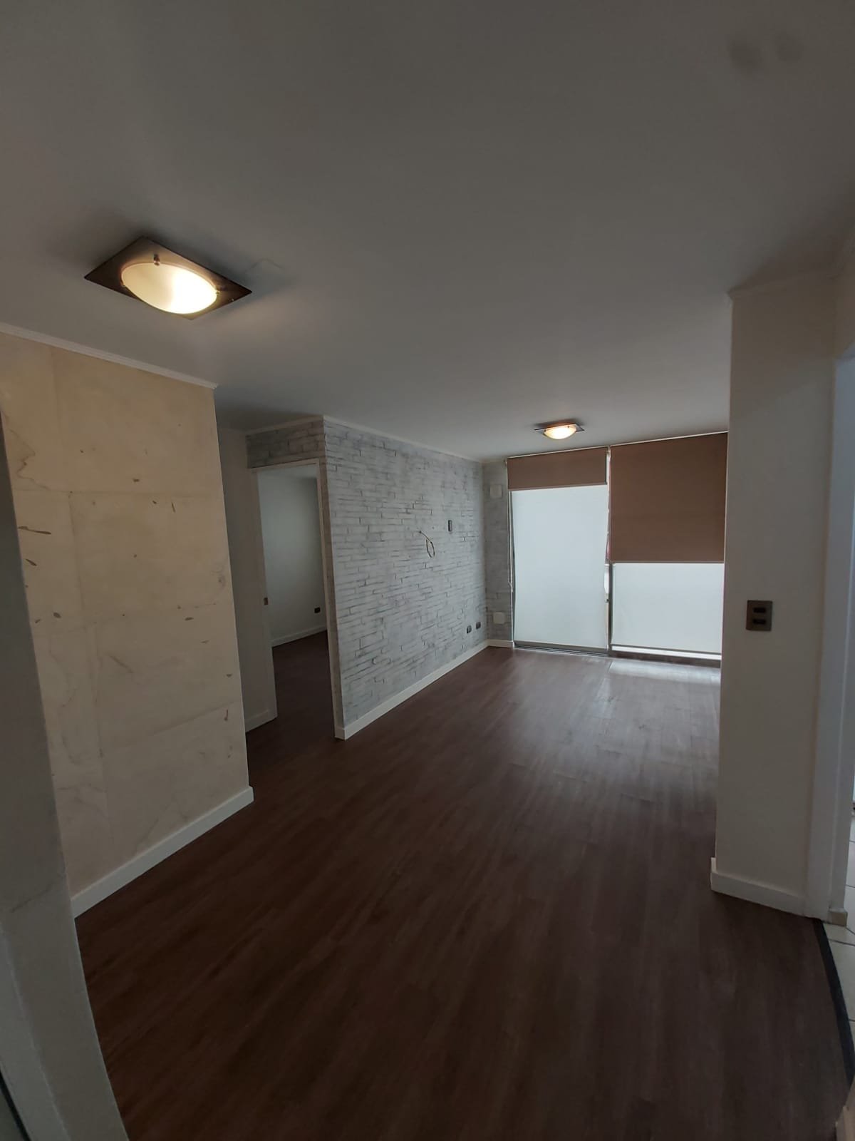 Living con revestimiento decorativo en muros, proyecto en Ñuñoa
